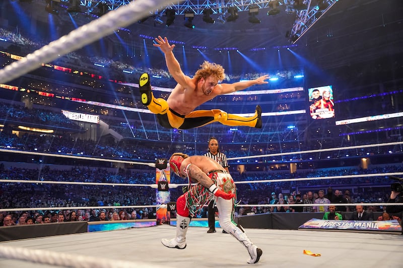 Logan Paul jumps over Rey Mysterio. 