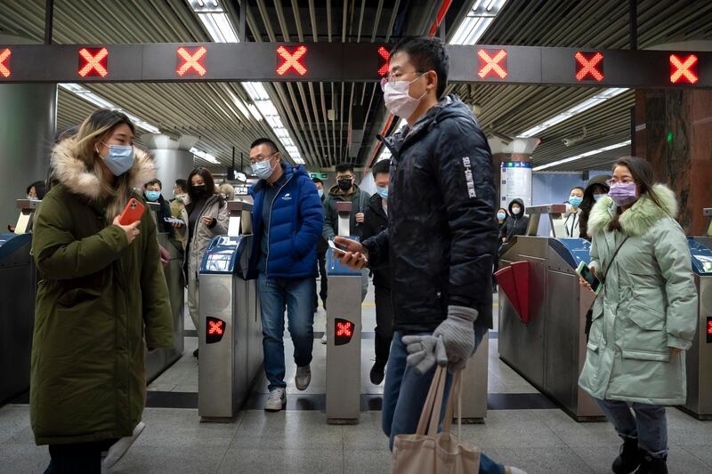 People wearing face masks to protect against the spread of the coronavirus walk through a subway station in Beijing. China has given more than 22 million COVID vaccine shots to date as it carries out a drive ahead of next month's Lunar New Year holiday, health authorities said Wednesday. AP