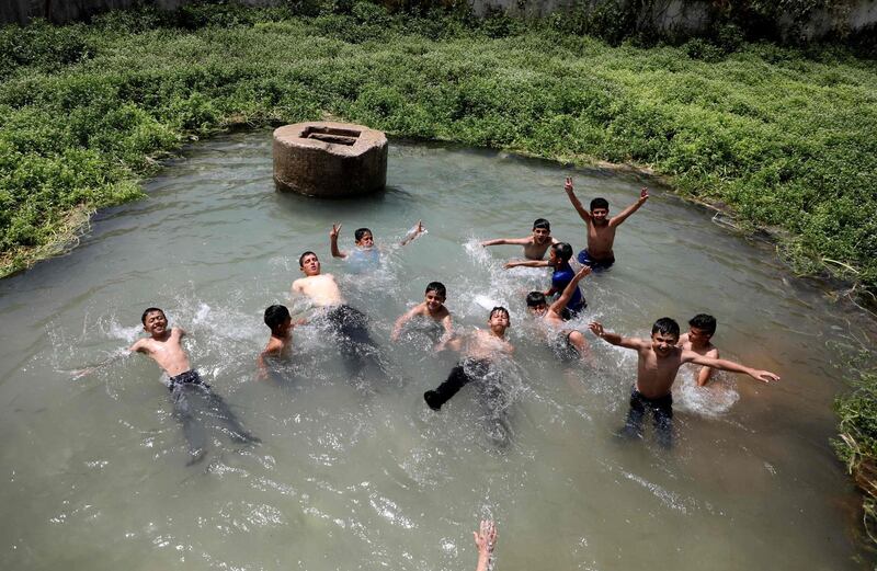 Palestinian children cool off in Al Fara spring near the village of Tubas in the Israeli-occupied West Bank, during a heat wave in Ramadan. AFP