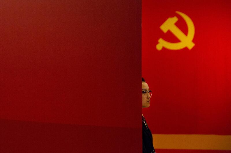 A staff member stands near a Communist Party flag at an exhibition to commemorate the 200th anniversary of the birth of Karl Marx at the National Museum in Beijing, China. Mark Schiefelbein / AP Photo