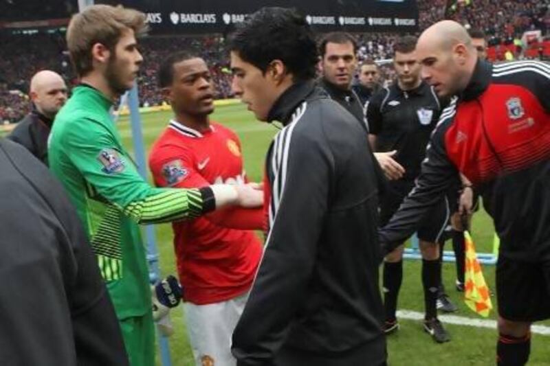 Already facing racism issues, when Luis Suarez, center, refused to shake the hand of Manchester United's Patrice Evra, second from left, the Liverpool striker was followed by a dark cloud the rest of the season.