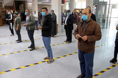 People wear protective masks, as part of precautionary measures against coronavirus disease (COVID-19), as they stand in a queue at a bank in Misrata, Libya. Reuters