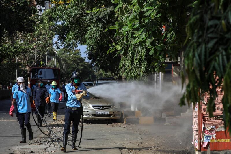 Members of the Mira Bhayander Municipal Corporation (MBMC) fire brigade spray disinfectant at residential areas during the coronavirus emergency lockdown in Mira Road near Mumbai.  EPA