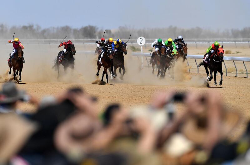 Horses in the first race thunder past the crowd at the Birdsville Races in Queensland, Australia.  AFP