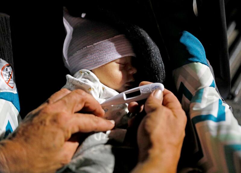 Wilmer Capps takes the temperature of his son Luke in a car park in Panama City, Florida. Luke was born three days after Hurricane Michael AP Photo