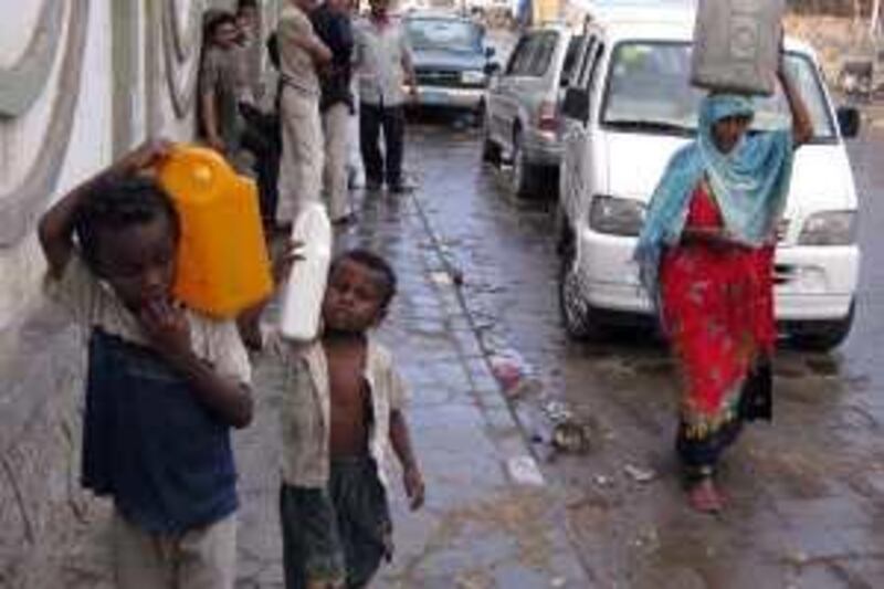 SEPTEMBER 2009, YEMEN: Khairyah Hasan Haza'a and her children carry their jars loaded with water  as they walk in al al Nahda zone in Taiz. Yemen is facing a chronic water shortage. Mohammed al Qadhi/The National
 *** Local Caption ***  wa-4.jpg