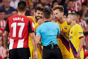 Barcelona's Gerard Pique, second left, talks with the referee during their La Liga match against Athletic Bilbao. AP Photo