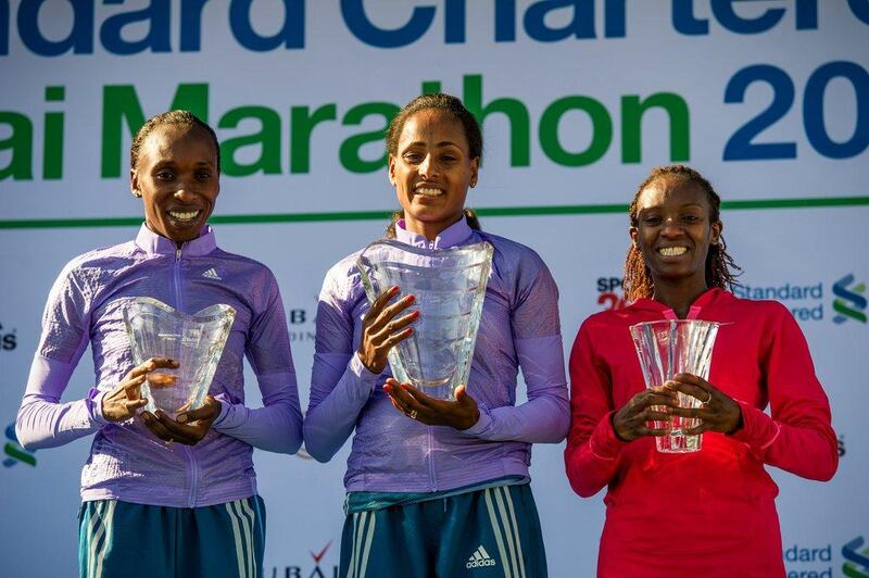 2015 Dubai Marathon winner Aselefech Mergia of Ethiopia, centre, shown with her trophy next to second place finisher Gladys Cherono, left, of Kenya, and Lucy Kabuu, right, also of Kenya, after Friday's race. Stephen Hindley / AP