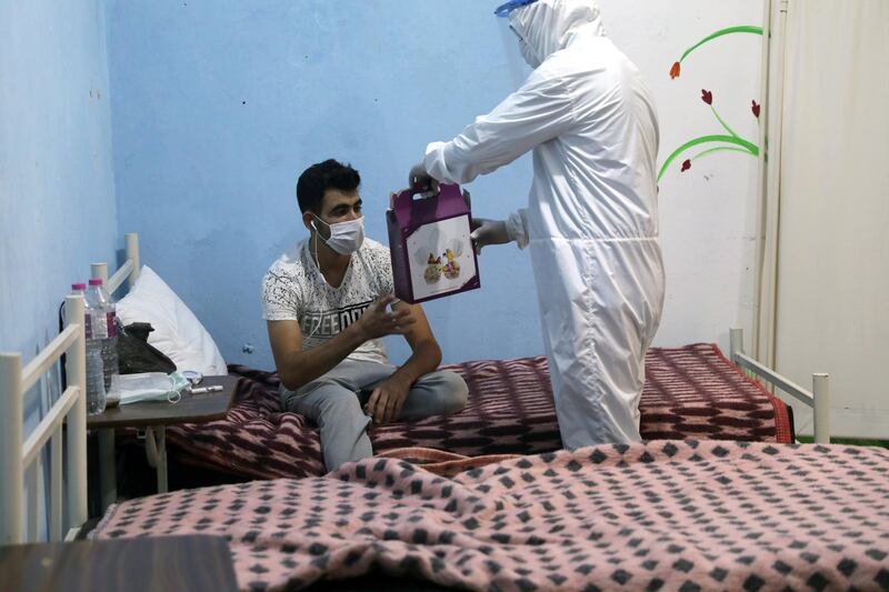 Meals are handed out to a patient at the community treatment centre in Syria's Ariha city. EPA