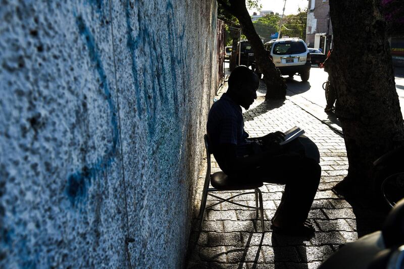 A man reads the Quran as he sits outside the Masjid At-Tawheed mosque in Port-au-Prince, Haiti.  AFP