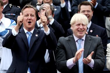 Britain's Prime Minister David Cameron gestures next to London Mayor Boris Johnson while viewing a parade of British Olympic and Paralympic athletes through London September 10, 2012. Tens of thousands of Britons took to the streets of London on Monday to welcome the stars of the Olympic and Paralympic Games and celebrate a summer of sport that surprised even the most optimistic by lifting the national mood.REUTERS/David Davies/POOL (BRITAIN - Tags: SPORT OLYMPICS POLITICS CITYSPACE)