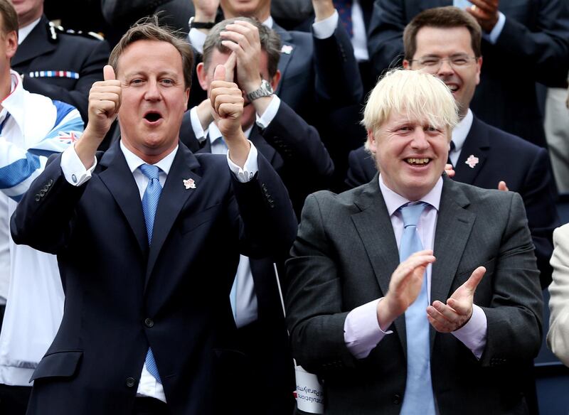 Britain's Prime Minister David Cameron gestures next to London Mayor Boris Johnson while viewing a parade of British Olympic and Paralympic athletes through London September 10, 2012. Tens of thousands of Britons took to the streets of London on Monday to welcome the stars of the Olympic and Paralympic Games and celebrate a summer of sport that surprised even the most optimistic by lifting the national mood.REUTERS/David Davies/POOL  (BRITAIN - Tags: SPORT OLYMPICS POLITICS CITYSPACE)