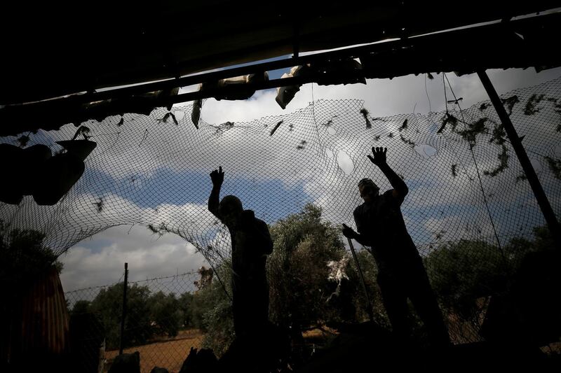Palestinians fix a damaged fence at the site of an Israeli air strike in Gaza City. Reuters