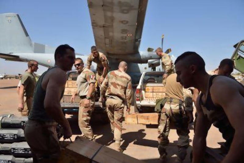 French troops carry weapons at the 101 military airbase near Bamako before their deployment to the north of Mali. France is using both air and ground power in the joint offensive with Malian soldiers.