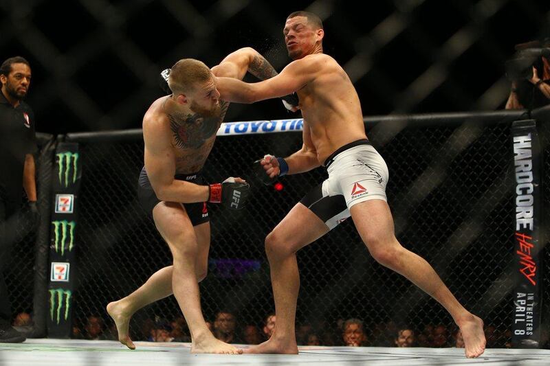 Conor McGregor (L) punches Nate Diaz during UFC 196 at the MGM Grand Garden Arena on March 5, 2016 in Las Vegas, Nevada.   Rey Del Rio/Getty Images/AFP