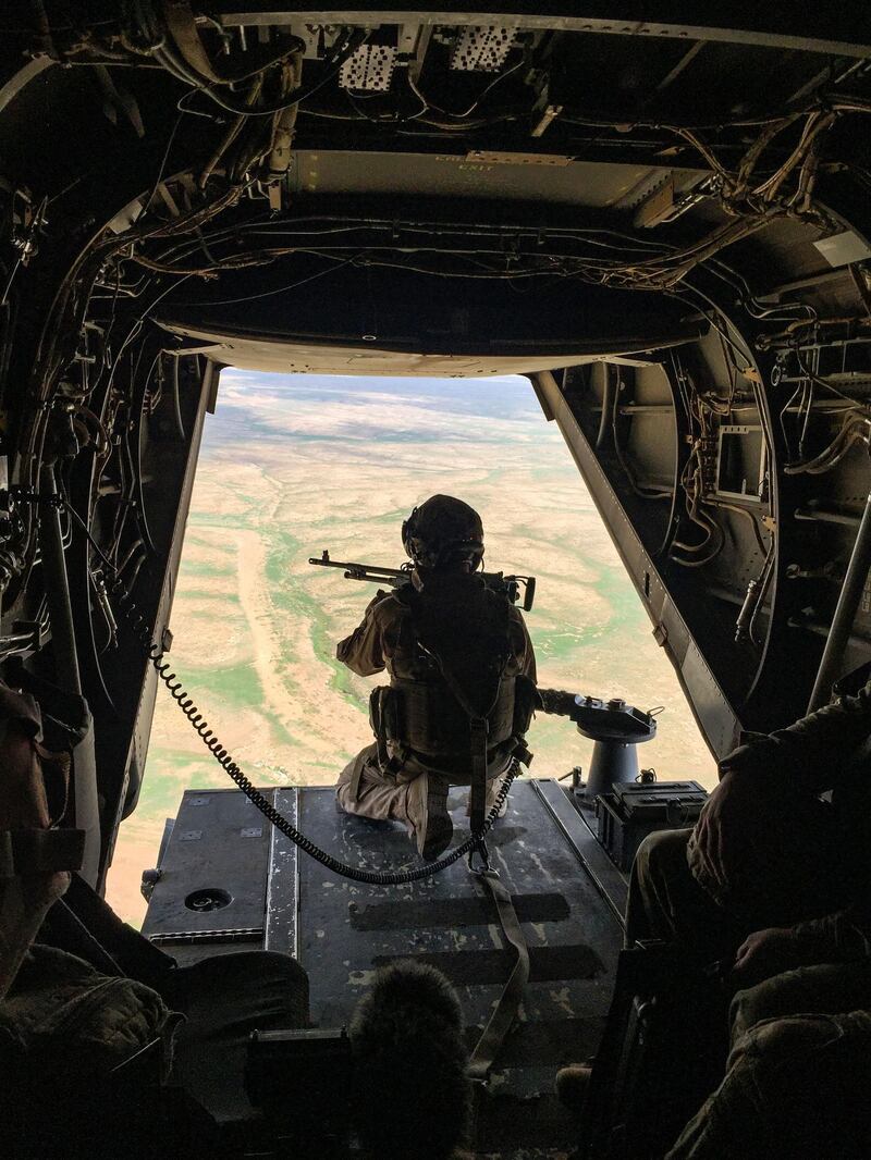 A gunner mans a machine gun at the back of a US Marine Corps V-22 Osprey flying near a French artillery base near al-Qaim in Iraq's western Anbar province opposite Syria's Deir Ezzor region, a few kilometres away from the last scrap of territory held by IS, on February 9, 2019.  / AFP / Daphné BENOIT
