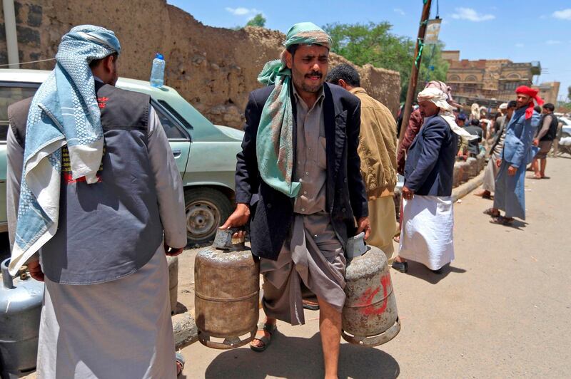 A Yemeni man carries gas cylinders afer filling them up amid increasing shortages in the Yemeni capital Sanaa, on September 2, 2018. (Photo by Mohammed HUWAIS / AFP)