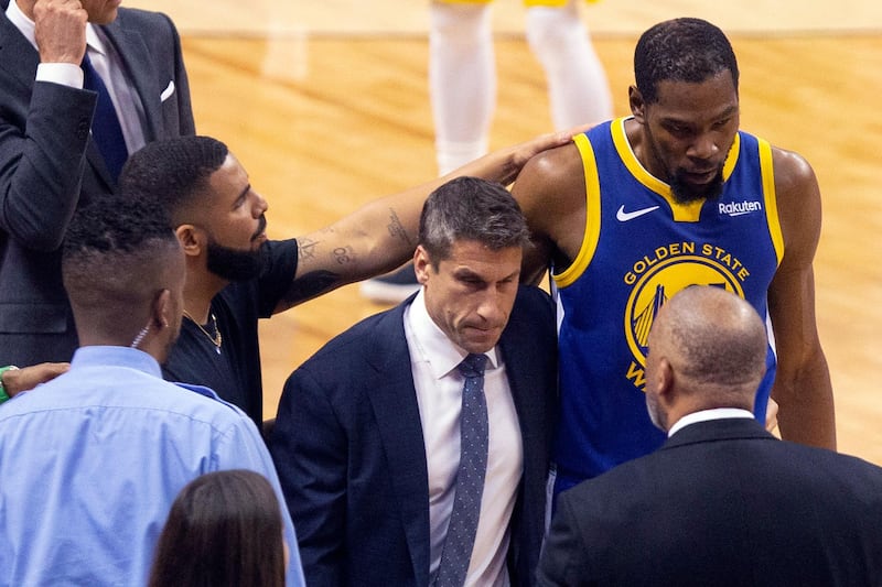 Golden State Warriors forward Kevin Durant, right, is consoled by Drake as he walks off the court after sustaining an injury during first half. AP Photo