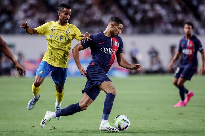 Paris Saint-Germain's Achraf Hakimi fights for the ball with Al Nassr's Abdulrahman Ghareeb. AFP