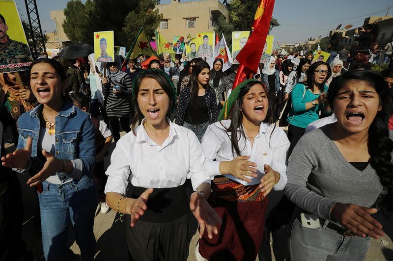 Kurdish and Arab protesters chant slogans against Turkish President Tayip Erdogan as they walk during a march to the United Nations Headquarters in the town of Qamishli, Syria. REUTERS