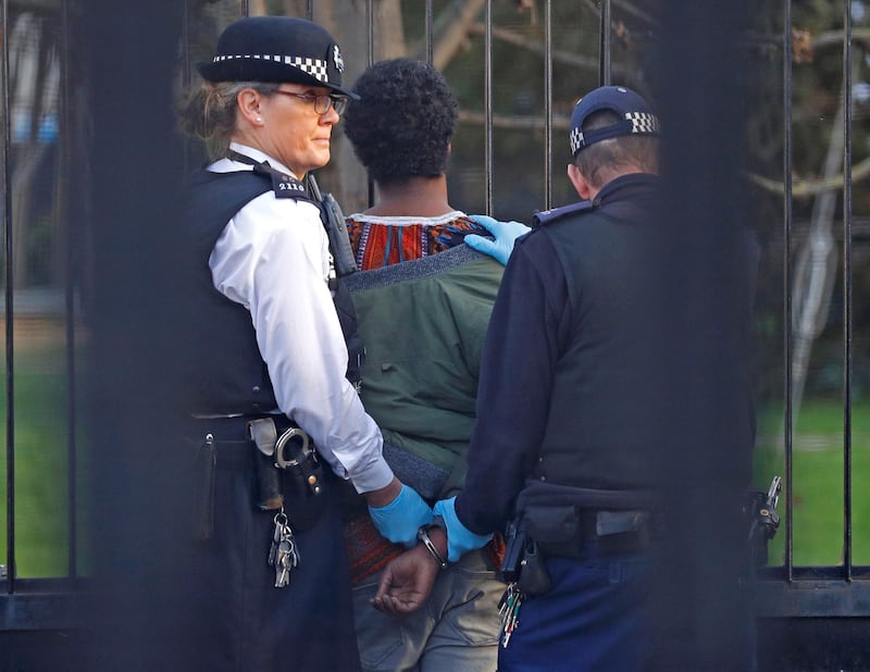 Police restrain a man inside the grounds of the Houses of Parliament. Reuters