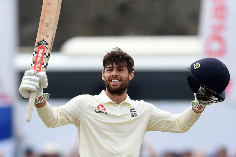 England's Ben Foakes raises his bat and helmet in celebration after scoring a century (100 runs) during the second day of the opening Test match between Sri Lanka and England at the Galle International Cricket Stadium in Galle on November 7, 2018. / AFP / ISHARA S. KODIKARA
