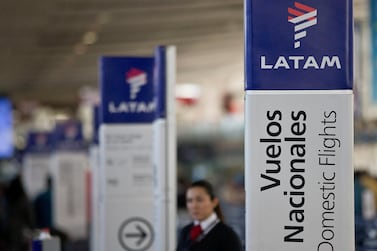 An agent of Latam airlines stands by the counters at the airport in Santiago, Chile. The airline said it is seeking Chapter 11 bankruptcy protection as it grapples with the sharp downturn in air travel sparked by the coronavirus pandemic. AP