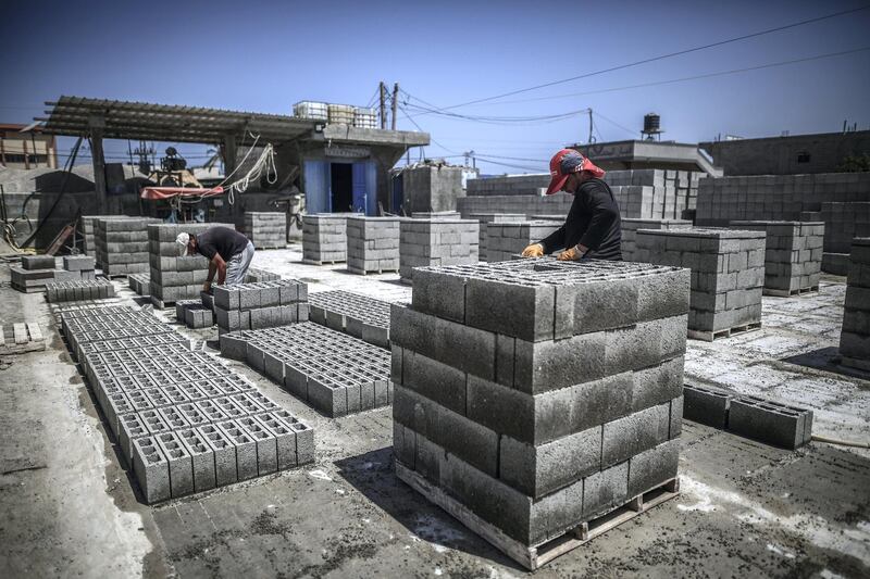 Workers produce construction bricks from the recycled rubble of buildings destroyed during the May rocket attacks. Sanad Latefa for The National