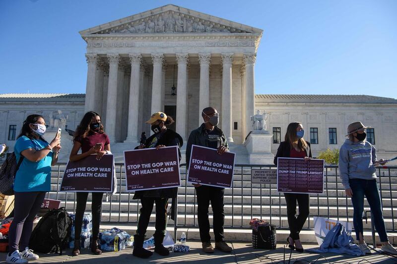 Demonstrators hold signs in front of the US Supreme Court in Washington, as the high court opened arguments in the long-brewing case over Affordable Care Act.  AFP