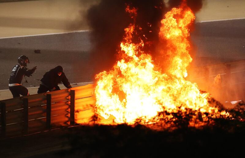 Fire marshalls try to put out the fire after Romain Grosjean's crash. Getty