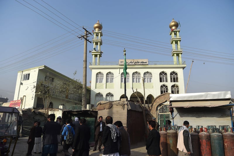 Afghan policemen and local residents gather outside the Imam Zaman Shiite mosque the day after a suicide attack during Friday evening prayers, in Kabul on October 21, 2017.
A strong smell of blood and flesh permeated the Imam Zaman mosque in Kabul on October 21 hours after dozens of Shiite worshippers were slaughtered by a suicide bomber during evening prayers. Broken glass and dust covered the red carpet, soaked in the blood of the men, women and children who had been praying on Friday when the attacker blew himself up, causing carnage in the cavernous prayer hall.
 / AFP PHOTO / WAKIL KOHSAR