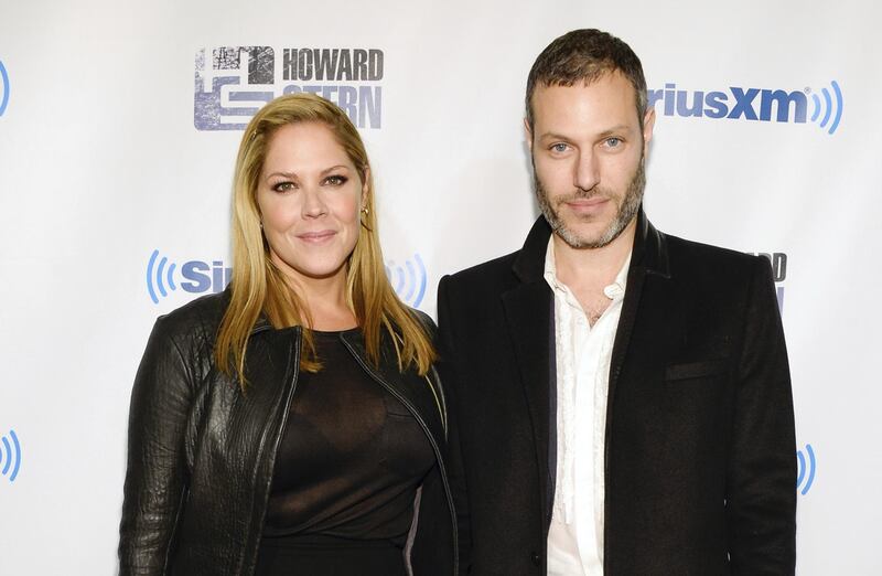 FILE - In this Jan. 31, 2014 file photo, actress Mary McCormack, left, and husband Michael Morris attend "Howard Stern's Birthday Bash," presented by SiriusXM, at the Hammerstein Ballroom in New York. McCormack has shared video of her husband's Tesla car shooting flames while in Southern California traffic. McCormack said in an accompanying tweet Friday, June 15, 2018, that there was "no accident" and the incident was "out of the blue." (Photo by Evan Agostini/Invision/AP, File)