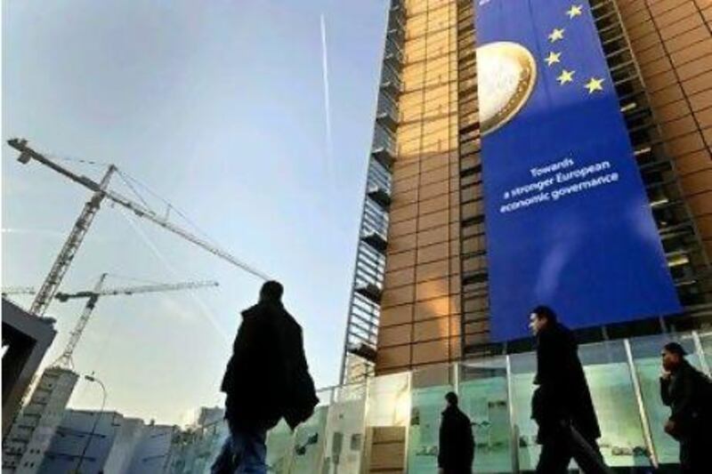 A euro banner promoting stronger European economic governance hangs on the side of the EU headquarters in Brussels.