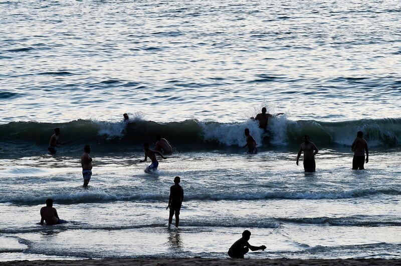 People swim at a public beach at Ramlet al-Bayda seaside during sunset in Beirut, Lebanon.  EPA