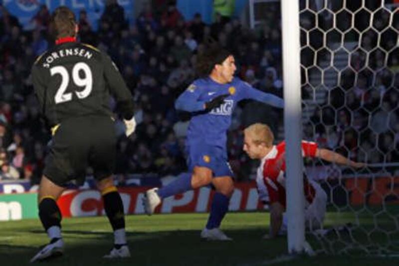 Manchester United's Carlos Tevez, centre, scores the only goal of the game at Stoke.