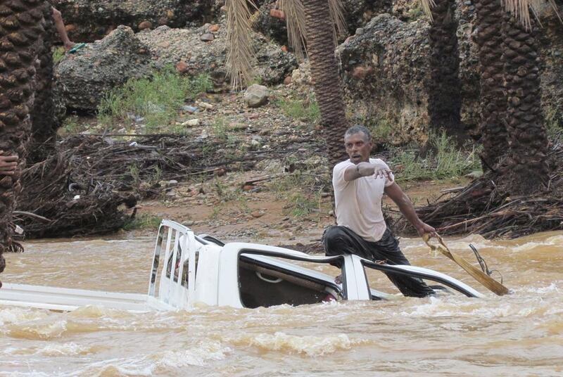 A man gestures as he tries to save a vehicle swept away by flood waters on Yemen’s Socotra island on November 2, 2015. Reuters