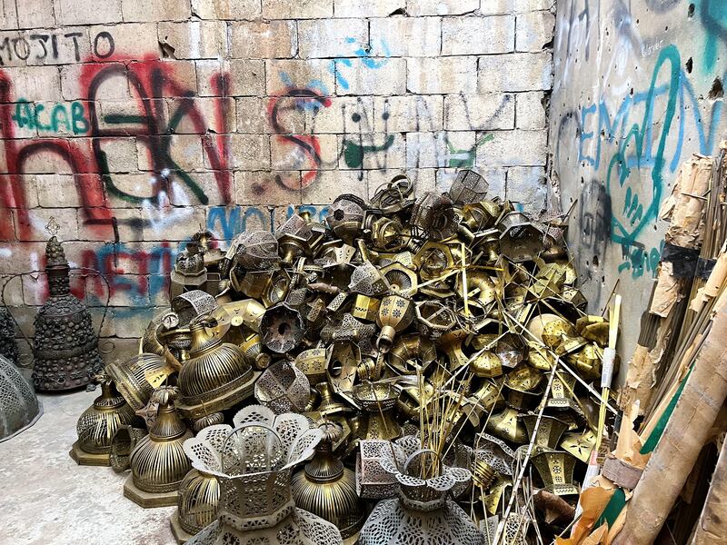 Hundreds of broken copper and brass lantern parts in a pile at the exhibiton.