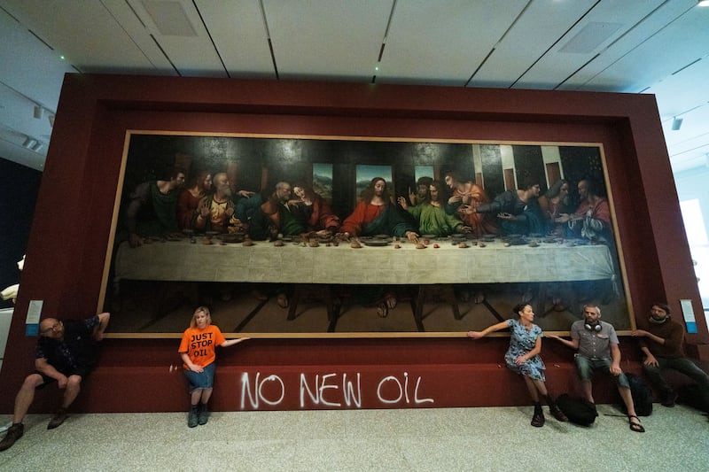 Five Just Stop Oil activists spray paint the wall and glue themselves to the frame of the painting the 'Last Supper' by Leonardo da Vinci on July 5, at the Royal Academy of Arts, London. Photo: In Pictures via Getty Images