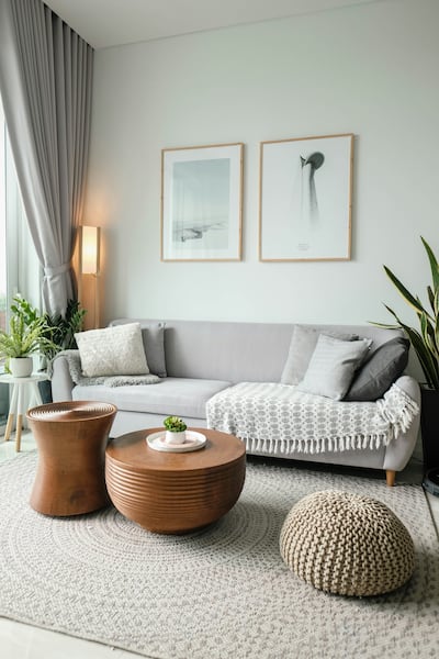 Complement a grey sofa with carved wooden tables, plus rugs, throws and cushions. Unsplash