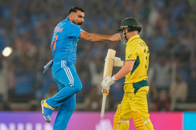 India's Mohammed Shami celebrates the dismissal of Australia's David Warner, right, caught by Virat Kohli at slip. AP 