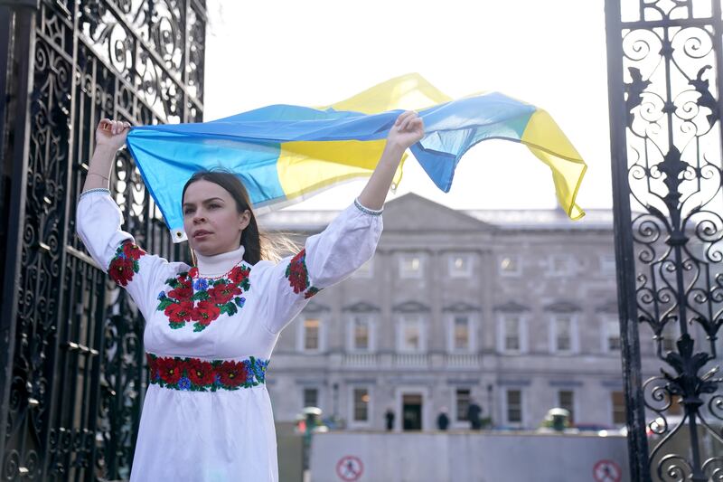 Ukrainian citizen Oleksandra Keshkeval, who is originally from Odesa but has lived in Dublin for a decade, holds the Ukrainian flag outside Leinster House, Dublin, before Mr Zelenskyy's address. PA