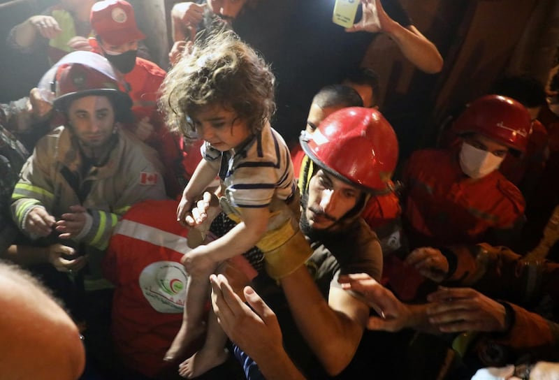 Rescuers carry a child that was evacuated from a building after a fuel tank exploded in the al-Tariq al-Jadida neighborhood of Beirut, Lebanon. REUTERS