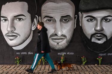 A man passes in front of a mural with portraits of victims of the 2020 Hanau shootings under a bridge in Frankfurt am Main, western Germany. AFP