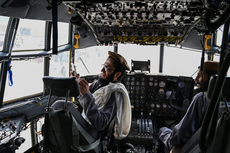 Taliban fighters sit in the cockpit of an Afghan Air Force aircraft at Kabul airport in August, 2021 after US troops pulled out of the country. AFP