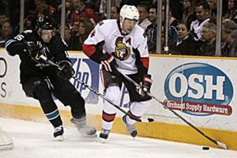 Ottawa Senators defenseman Chris Phillips, right, is chased by former teammate San Jose Sharks right wing Dany Heatley.