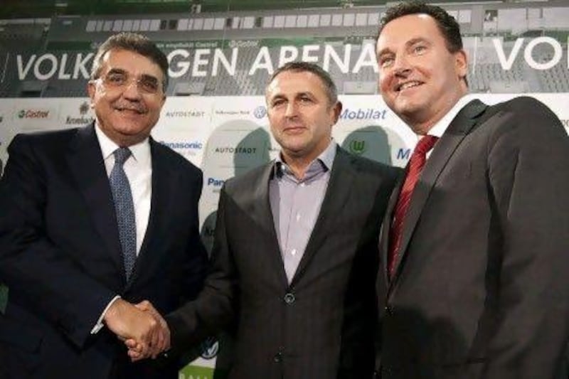 Klaus Allofs, centre, poses with Javier Garcia Sanchez, left, the chairman of the supervisory board of Wolfsburg, and Stephan Gruehsam, the vice chairman, after he made the move from Werder Bremen.