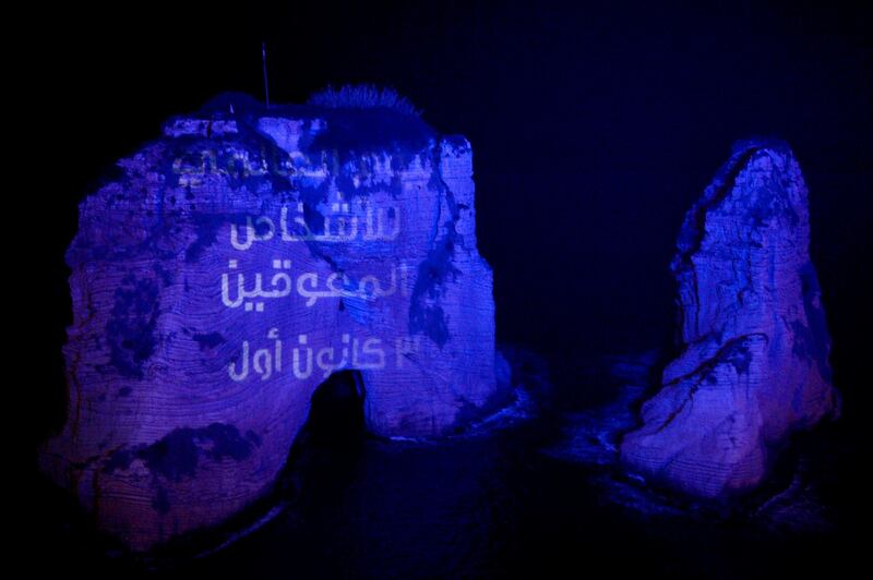 Lebanese landmark Raouche Rock is dipped in blue light to mark the International Day of Disabled Persons in Beirut. EPA