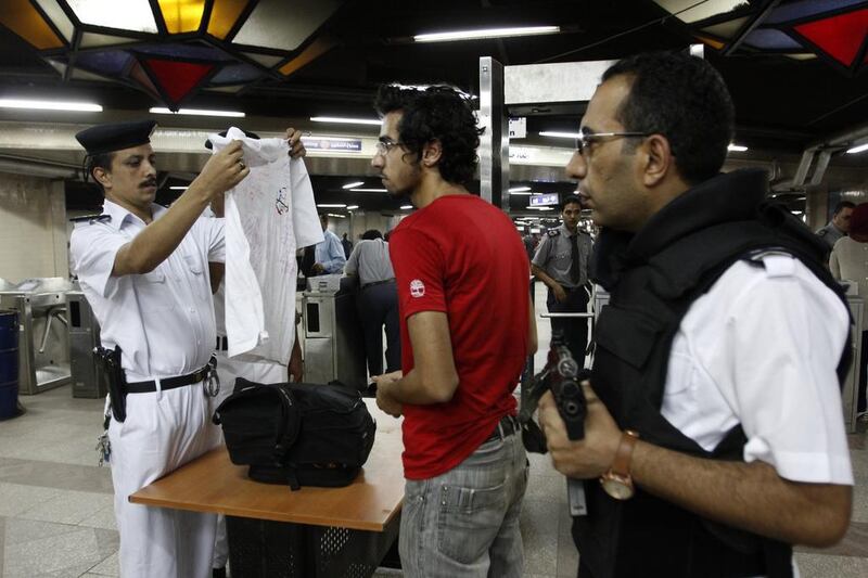 An Egyptian policeman inspects a commuters belongings at Al Shohadaa (Martyrs) metro station, in Cairo, Egypt.