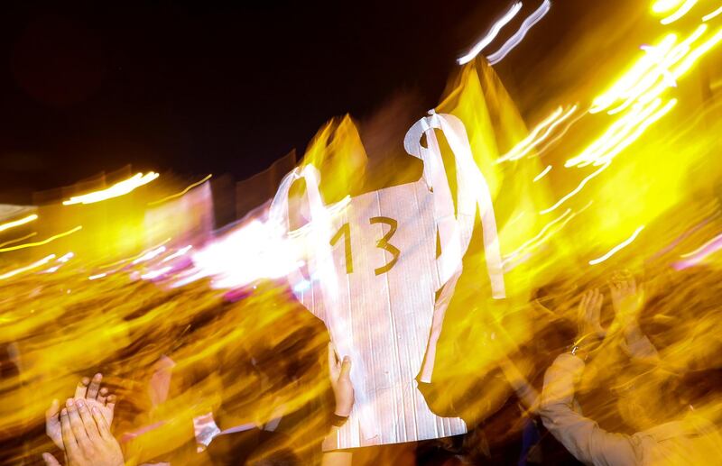 Real Madrid fans celebrate holding up a cardboard trophy with the number 13 near the Cibeles fountain in central Madrid. Paul Hanna / Reuters