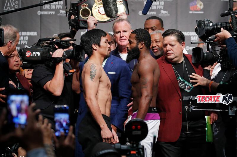Manny Pacquiao, left, and Adrien Broner pose during weigh-ins Friday, Jan. 18, 2019, in Las Vegas. The two are scheduled to fight in a welterweight championship boxing bout Saturday. (AP Photo/John Locher)